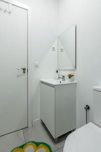a white bathroom with a sink and a mirror at Studio 1 Soto Parking Renfe in Torrejón de Ardoz