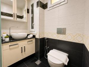 a bathroom with a white toilet and a sink at Appartement Spacieux à Constantine in El Khroub