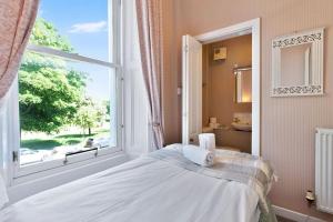 a bedroom with a bed and a large window at GuestReady - Links View in Edinburgh +14 photos