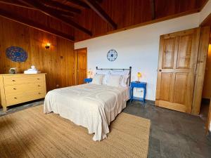 a bedroom with a large bed and wooden walls at Casa da Terra Alta in Santo Amaro