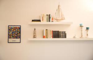 a white shelf with books and a boat on it at Capalbio Relax - Super terrazza in Capalbio