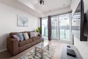 a living room with a couch and a large window at 1 BR plus Ent District,MTCC,Jays in Toronto
