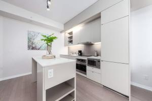 a kitchen with white cabinets and a plant on a counter at 1 BR plus Ent District,MTCC,Jays in Toronto