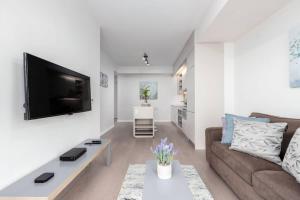 a living room with a couch and a tv on a wall at 1 BR plus Ent District,MTCC,Jays in Toronto +21 photos