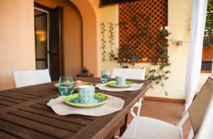 a wooden table with two plates of food and glasses at Capalbio Relax - Super terrazza in Capalbio