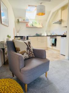 a living room with a chair and a kitchen at Urban Stay Apartment in Aylsham