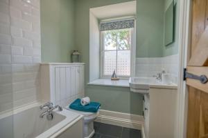 a bathroom with a tub and a toilet and a sink at Hafod in Tenby