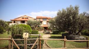 a house with a fence in front of a yard at Capalbio Relax - Super terrazza in Capalbio