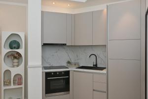 a kitchen with white cabinets and a sink at Casa Dalmatia in Krvavica