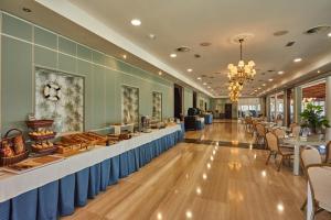 a restaurant with a long line of tables and chairs at Silken Gran Hotel del Sella in Ribadesella