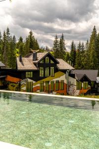 a house with a swimming pool in front of it at Котеджі Грань in Yablunytsya