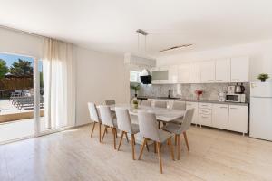 a kitchen and dining room with a table and chairs at Vila Martina in Novalja