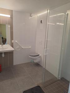a bathroom with a shower and a toilet and a sink at Hôtellerie Abbaye Port du Salut in Entrammes
