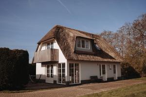 a thatched house with a thatched roof at Dutchen Waddenduyn in Den Burg