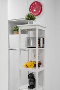 a white shelf with food and a clock on a wall at Apartamento nuevo completo 2 in Torrejón de Ardoz +9 photos