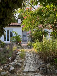 a stone path leading to a white house with pink flowers at La Vilo Dòu Verdon in Roumoules