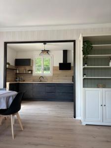 a kitchen with black cabinets and a sink and a table at La Vilo Dòu Verdon in Roumoules