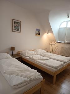 two twin beds in a room with a window at Euro Apartman in Debrecen