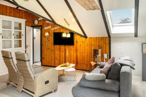 a living room with a couch and chairs and a tv at Elfenwinkel am See in Gartow