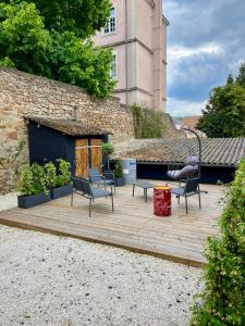 a wooden deck with chairs and a building at Appart Hotel NuitéeJour Le Mans Centre Jaurès in Le Mans