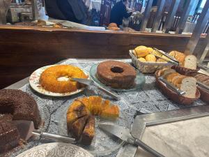 a table with different types of bread and pastries at Bento palace hotel in Assis