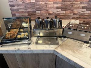 a kitchen counter with many trays of food at Bento palace hotel in Assis