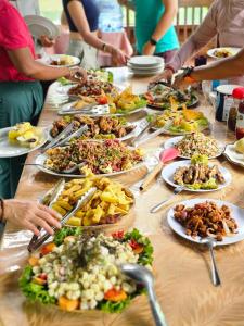 a group of people standing around a table full of food at Dorado Lodge in Manú