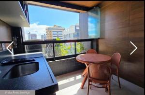 eine Küche mit Tisch und Stühlen und einem Fenster in der Unterkunft Sun Smart Prime in Cabedelo