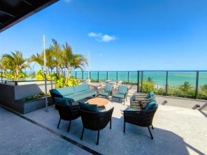 eine Terrasse mit Tisch und Stühlen und dem Meer in der Unterkunft Sun Smart Prime in Cabedelo