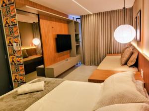 ein Hotelzimmer mit zwei Betten und einem Fernseher in der Unterkunft Sun Smart Prime in Cabedelo + 21 Fotos