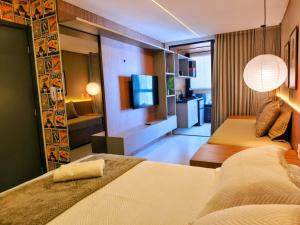 ein Hotelzimmer mit zwei Betten und einem Fernseher in der Unterkunft Sun Smart Prime in Cabedelo