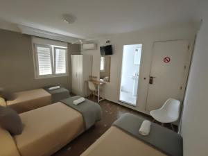 a hotel room with two beds and a window at AYAMONTE ROOMS 43 in Ayamonte