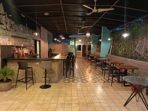 a bar with chairs and tables in a restaurant at Senda Adults Only Hostel in Manuel Antonio