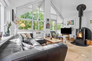 a living room with a leather couch and a fireplace at 8552-Grenaa-Polderrevsvej-17 in Grenå