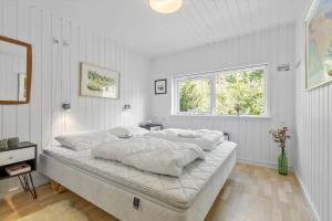 a bedroom with a large bed with white sheets at 8552-Grenaa-Polderrevsvej-17 in Grenå