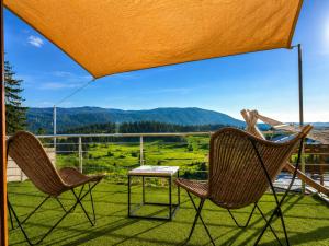 two chairs and a table on a balcony with a view at Pine apartment Vlašić in Vlasic