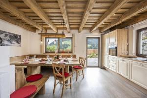 a kitchen with a large wooden table and chairs at Chalets Premium Dachstein in Forstau +24 photos