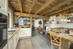 a kitchen with wooden ceilings and a table with chairs at Chalets Premium Dachstein in Forstau