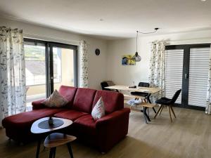 a living room with a red couch and a table at Apartment Wiedehopf in Vogtsburg