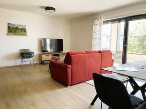 a living room with a red couch and a television at Apartment Wiedehopf in Vogtsburg +36 photos