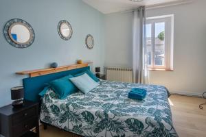 a bedroom with a bed with a blue comforter at Demeure Olea in Chérac