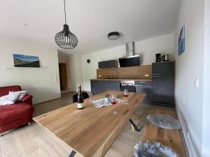 a living room with a wooden table and a red couch at Apartment Rotmilan in Vogtsburg