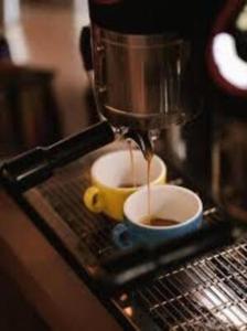 a coffee maker is making a cup of coffee at Nexus Apartment in Podgorica