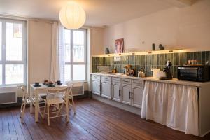 a kitchen with a counter and a table with a microwave at a charming little apartment in Cluny