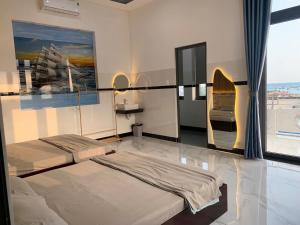 a bedroom with two beds and a large window at CoCo SEA in Mui Ne
