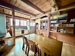 a dining room with a large wooden table and chairs at 未来のふるさと村 in Yamaguchi