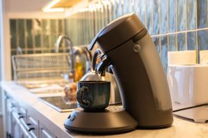 a black coffee maker sitting on a kitchen counter at a charming little apartment in Cluny +24 photos