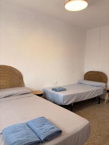a room with two beds with towels on them at Cala Queralt Rooms in Sagunto