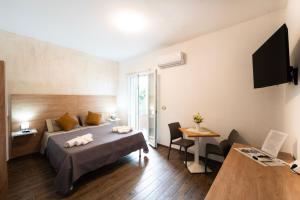 a hotel room with a bed and a table and chairs at Miluna Affittacamere in Siniscola