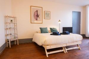 a bedroom with a large bed in a room at a charming little apartment in Cluny